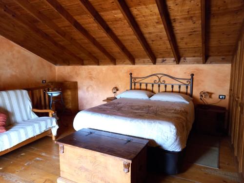 a bedroom with a large bed and a couch at Casa Maria in Agulo