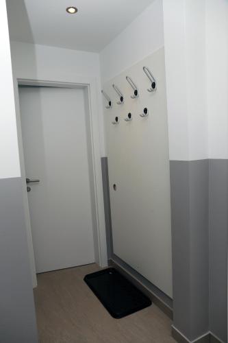a room with white walls and a door with hooks at Appartement Bär in Eben im Pongau