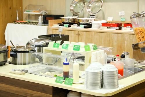 a kitchen with a counter with plates and dishes at Hotel Econo Fukui Station in Fukui