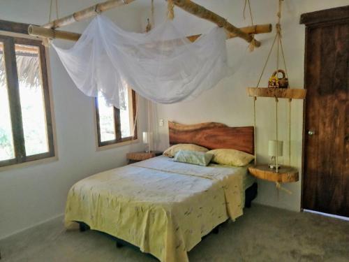 1 dormitorio con 1 cama con mosquitera en El Eden Bungalows en Mazunte