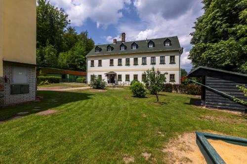 una gran casa blanca con patio en Pension Hubert, en Raspenava