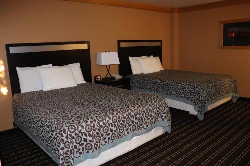 a hotel room with two beds and a lamp at Prairie Inn Holmen La Crosse Area in Holmen