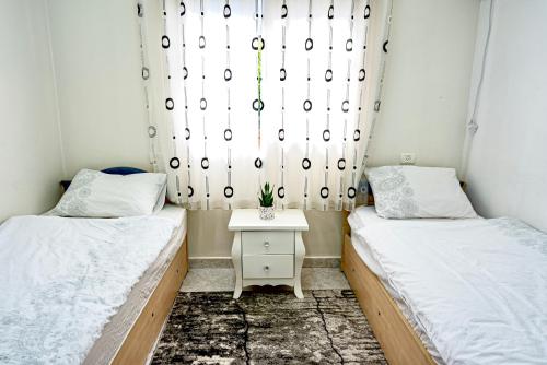 two beds in a small room with a window at toptop1 in Majdal Shams