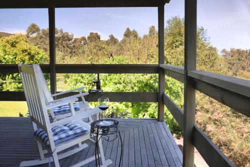 a porch with two white chairs and a table at Lavender Farm in Healesville
