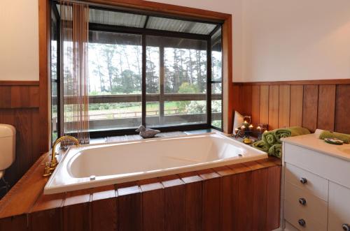 baño con bañera grande y ventana en Lavender Farm, en Healesville