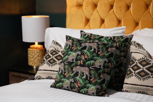 a bedroom with a bed with pillows and a lamp at Lonsdale house by Orenda-Luxe in Llandudno