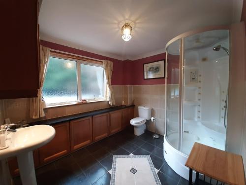 a bathroom with a tub and a toilet and a sink at High March in Drumnadrochit