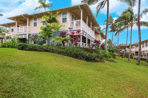 a large house with palm trees in front of it at North Shore Kauai Hideaway condo in Princeville