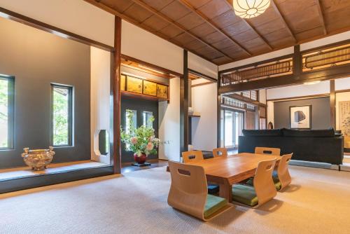 a dining room with a table and chairs and a piano at Heritage Osaka in Tondabayashi