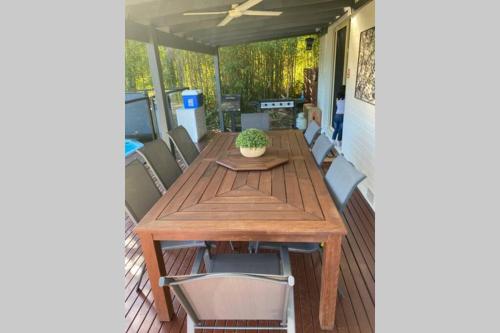 a wooden table and chairs on a porch at Relax in the spa with views opposite Lake Eildon in Goughs Bay