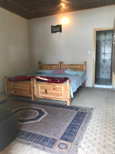 a bedroom with a wooden bed in a room at ViveGee Cottage Khanipur Ayubia in Ayubia