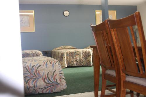 a room with a chair and a bed and a table at Heidi's Inn in Ilwaco