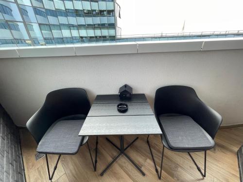 a table and chairs in a room with a window at Pupin Palace Apartments in Novi Sad
