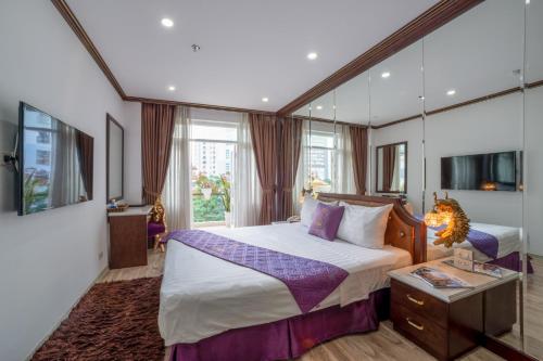 um quarto com uma cama grande e um espelho em Hanoi Suji Hotel em Hanói