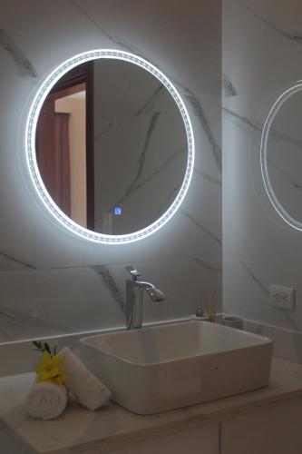 bagno con lavandino e specchio rotondo di Casa Coco de Mer 1 a Tamarindo