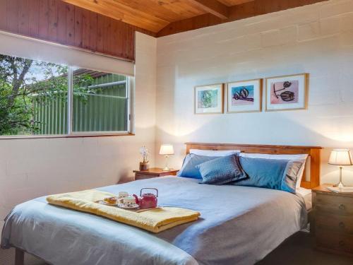 a bedroom with a bed with a tray on it at Captain's Lookout in Bellawongarah