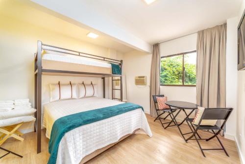 a bedroom with a bed and a table and chairs at Rizzu Marina Hotel in Balneário Camboriú