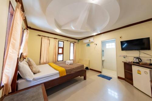 a bedroom with a bed and a tv in a room at Tom Pizza Resort in Ko Samed