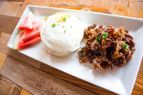 a plate of food with ice cream and fruit at Estancia De Lorenzo Tarlac in Tarlac