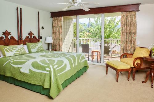 1 dormitorio con 1 cama y balcón en The Cliffs at Princeville, en Princeville
