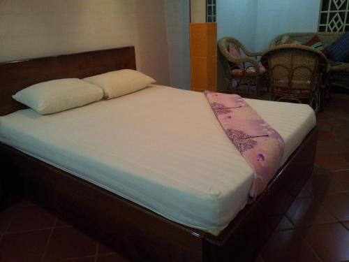 a bed with two pillows on top of it at Javier Guesthouse in Tbeng Meanchey