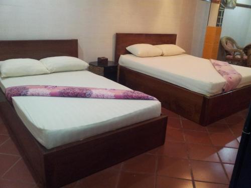 two twin beds in a room with at Javier Guesthouse in Tbeng Meanchey
