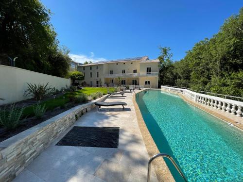a swimming pool in front of a house at MOULIN DE L'OULETTE in Soubès