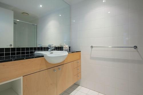 a bathroom with a sink and a mirror at Papillon Coolum in Coolum Beach