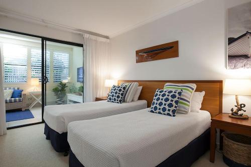 a hotel room with two beds and a balcony at Papillon Coolum in Coolum Beach
