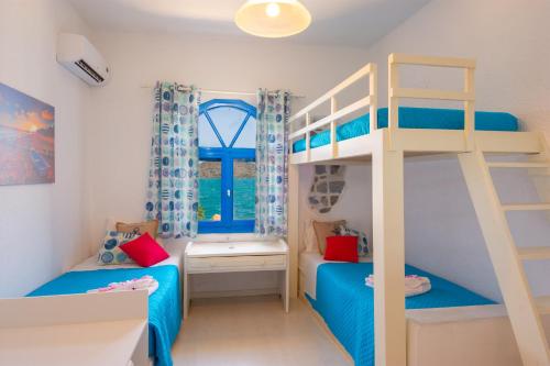 a bedroom with two bunk beds and a window at Eleftheria Sea Side Traditional House in Elounda