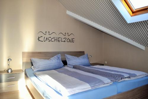 a bed with blue and white sheets in a bedroom at Gästehaus Klein in Hilders