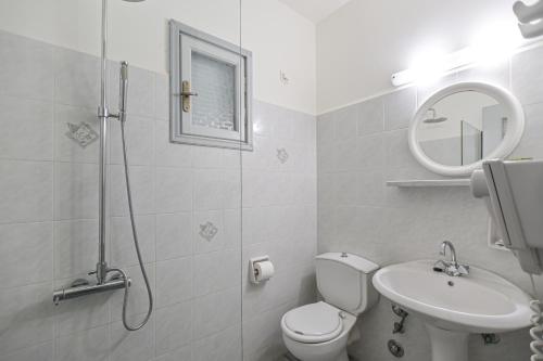 a bathroom with a toilet and a sink and a mirror at Soula Naxos in Naxos Chora