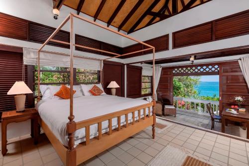 a bedroom with a canopy bed and a balcony at Baan Khunying - Secluded Phuket Beachfront Villa - SHA Certified in Rawai Beach