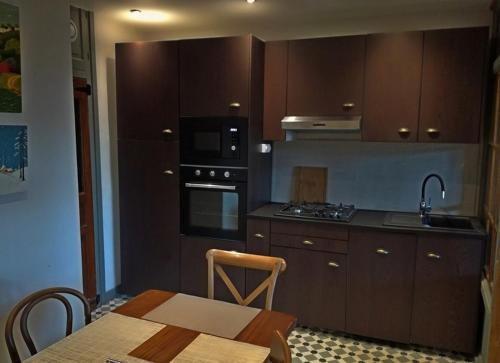 a kitchen with wooden cabinets and a table with a table sidx sidx sidx at Gîte les 4 Vents in Pradelles