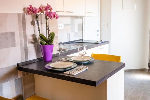 stół z dwoma kieliszkami i wazon z kwiatami w obiekcie Speranza apartment 2 w Krku