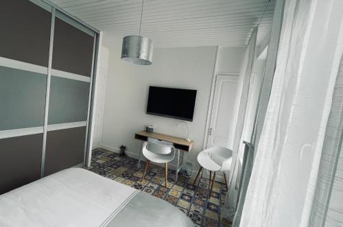 a bedroom with a bed and a desk and a television at le numero 100 in Nancy