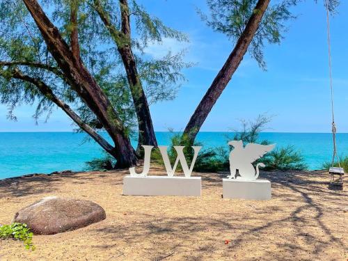 two sculptures on the beach with the ocean in the background at JW Marriott Phuket Resort and Spa in Mai Khao Beach