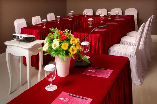a group of tables with wine glasses and flowers on them at Gallery Prawirotaman Hotel in Yogyakarta