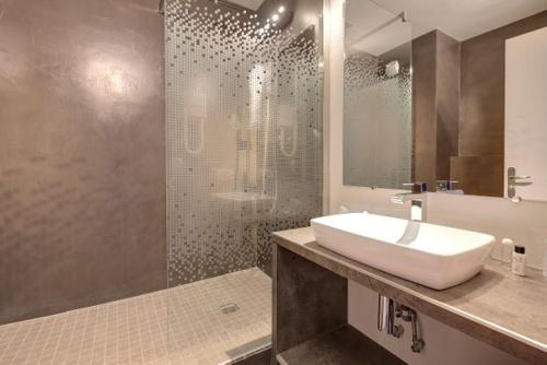 a bathroom with a sink and a shower at Hôtel Le Nautic in Arcachon