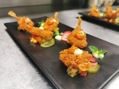a black plate topped with fried food on a table at Abelana River Lodge in Phalaborwa