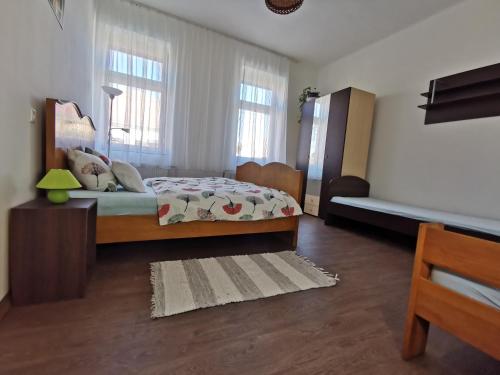 a bedroom with a bed and two windows at Green Garden House in Gencsapáti