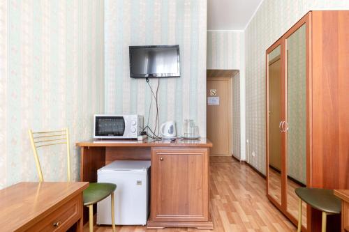 a room with a kitchen with a microwave and a table at RA Kuznechny 19 in Saint Petersburg