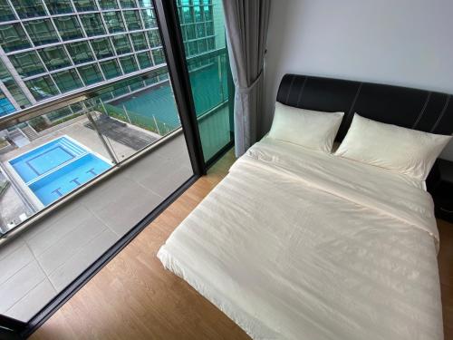 - une chambre avec un lit et une grande fenêtre dans l'établissement Kuching Imperial Suites Cozy Corner, à Kuching