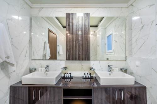 ハニオティスにあるSunny Villas Exclusiveのバスルーム(シンク2台、大きな鏡付)
