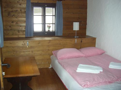 1 dormitorio con 1 cama con mesa y ventana en Ferienwohnung Hahn, en Sonnenalpe Nassfeld