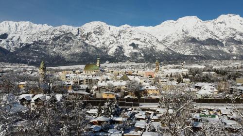 a city covered in snow with mountains in the background at Gasthof Badl - Bed & Breakfast in Hall in Tirol