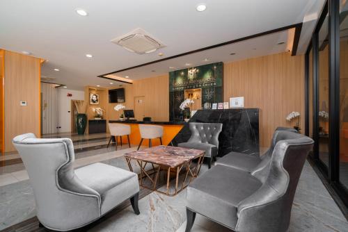 eine Lobby mit Stühlen, einem Tisch und einer Bar in der Unterkunft KK Karon Kata Boutique Hotel in Kata Beach
