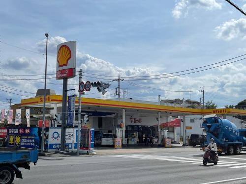 a gas station with a man on a motorcycle in front at Bessalov Home 2nd room friendly house in Tokyo