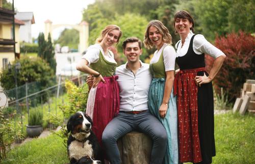 a group of people posing for a picture with a dog at Gasthof Badl - Bed & Breakfast in Hall in Tirol