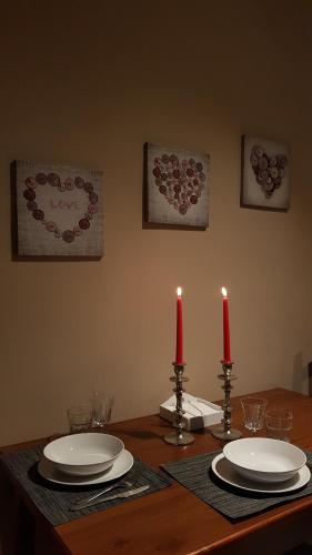 a table with two red candles and plates on it at Ca di Biella in Biella